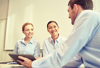 Image showing smiling businesspeople with tablet pc in office