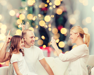 Image showing happy family with camera at home