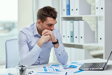 Image showing stressed businessman with laptop and papers