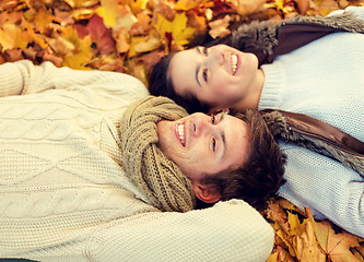 Image showing close up of smiling couple lying in autumn park