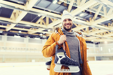 Image showing happy young man with ice-skates on skating rink