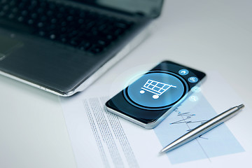 Image showing close up of smartphone with shopping cart icon