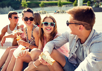 Image showing group of smiling friends sitting on city square