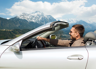 Image showing happy man driving cabriolet car over mountains