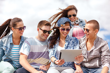 Image showing group of smiling teenagers looking at tablet pc