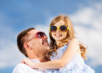 Image showing happy father and child in sunglasses over blue sky