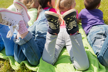 Image showing close up of kids lying on picnic blanket outdoors