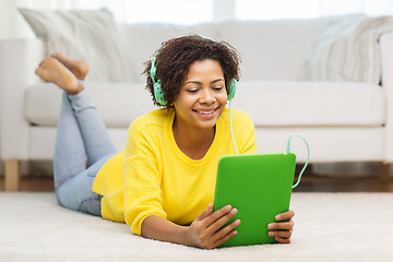 Image showing happy african woman with tablet pc and headphones