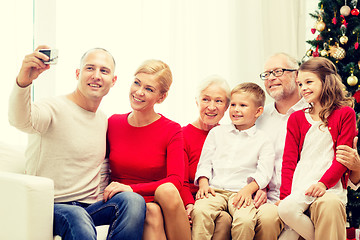 Image showing smiling family with camera at home