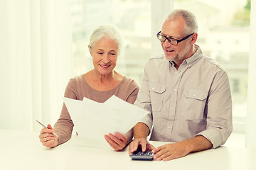 Image showing senior couple with papers and calculator at home