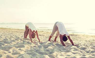 Image showing couple making yoga exercises outdoors