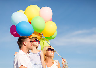 Image showing happy family with colorful balloons outdoors