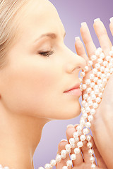 Image showing beautiful woman with sea pearls beads over violet