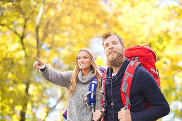 Image showing smiling couple with backpacks hiking over autumn