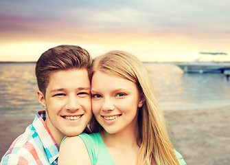 Image showing smiling couple hugging over beach background