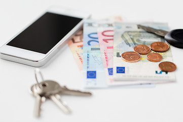 Image showing close up of smartphone, money and keys on table