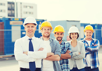 Image showing group of smiling builders in hardhats outdoors