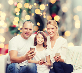 Image showing happy family with smartphones