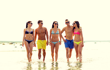 Image showing smiling friends in sunglasses on summer beach