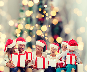 Image showing happy family in santa helper hats with gift boxes