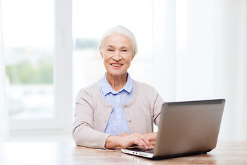 Image showing happy senior woman with laptop at home