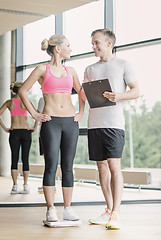 Image showing smiling man and woman with scales in gym