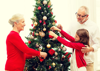 Image showing smiling family decorating christmas tree at home