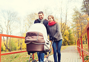 Image showing smiling couple with baby pram in autumn park