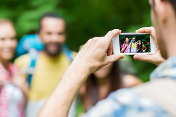 Image showing man photographing friends by smartphone