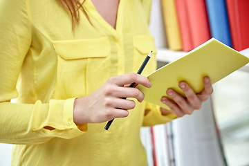 Image showing close up of female hands with notebook and pencil