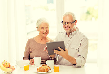 Image showing happy senior couple with tablet pc at home