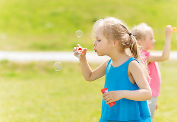 Image showing group of kids blowing soap bubbles outdoors