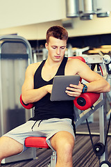 Image showing young man with tablet pc computer in gym