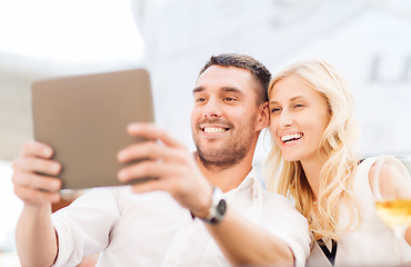 Image showing happy couple with tablet pc at restaurant lounge