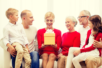 Image showing smiling family with gift at home