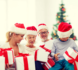 Image showing happy family in santa helper hats with gift boxes