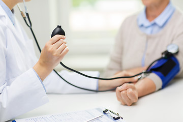 Image showing doctor with tonometer and senior woman at hospital