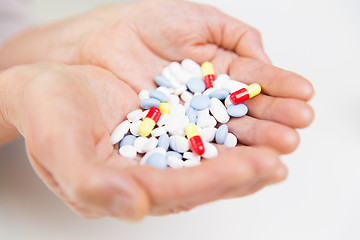 Image showing close up of senior woman hands with pills