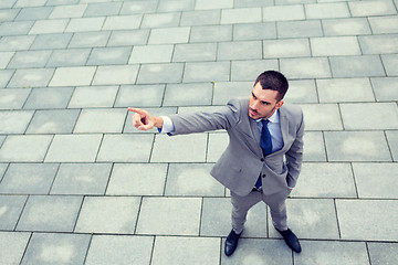 Image showing young smiling businessman outdoors from top