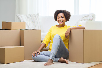 Image showing happy african woman with cardboard boxes at home