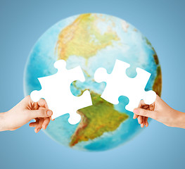 Image showing hands with white blank puzzle over earth globe