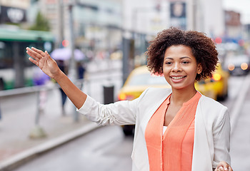 Image showing happy african woman catching taxi