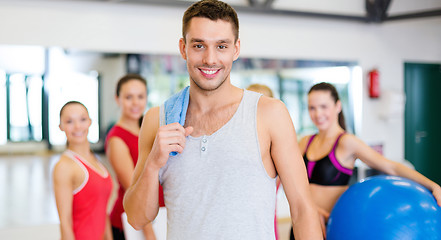 Image showing smiling man standing in front of the group in gym