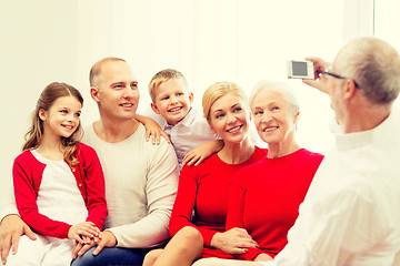 Image showing smiling family with camera at home