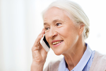 Image showing senior woman with smartphone calling at home