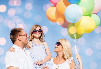 Image showing happy family with balloons over blue lights