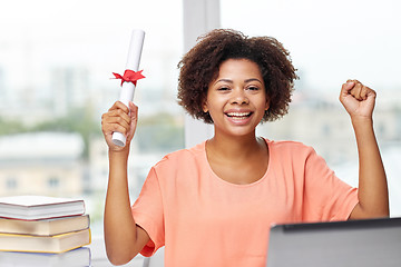 Image showing happy african woman with laptop, books and diploma