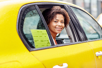 Image showing happy african american woman driving in taxi