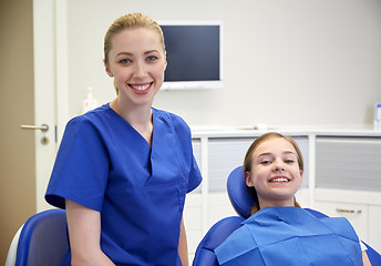 Image showing happy female dentist with patient girl at clinic