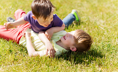 Image showing happy little boys fighting for fun on grass